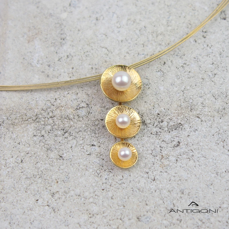 Εlegant gold pendant with three handmade motifs, one larger than the other and each with a white pearl in the centre
