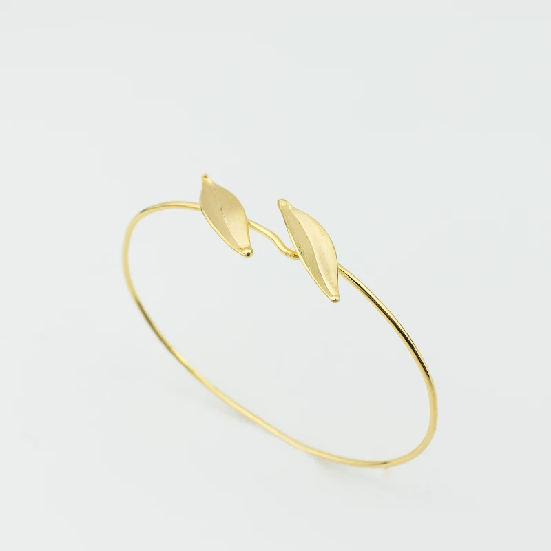Delicate gold bracelet in the round shape and decorated with two realistic embossed olive leaves