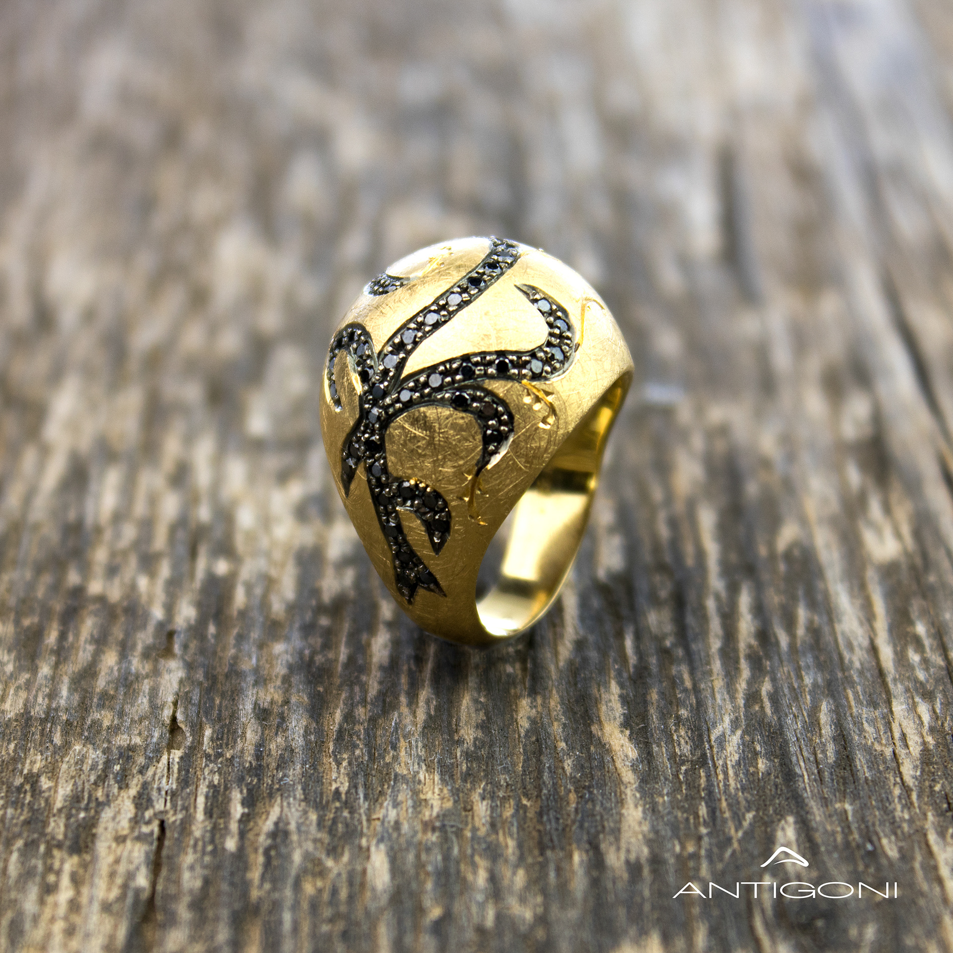 Εντυπωσιακό χρυσό δαχτυλίδι το οποίο είναι διακοσμημένο με μαύρα διαμάντια σε ένα περίτεχνο σχέδιο που μοιάζει με το φυτό κισσός