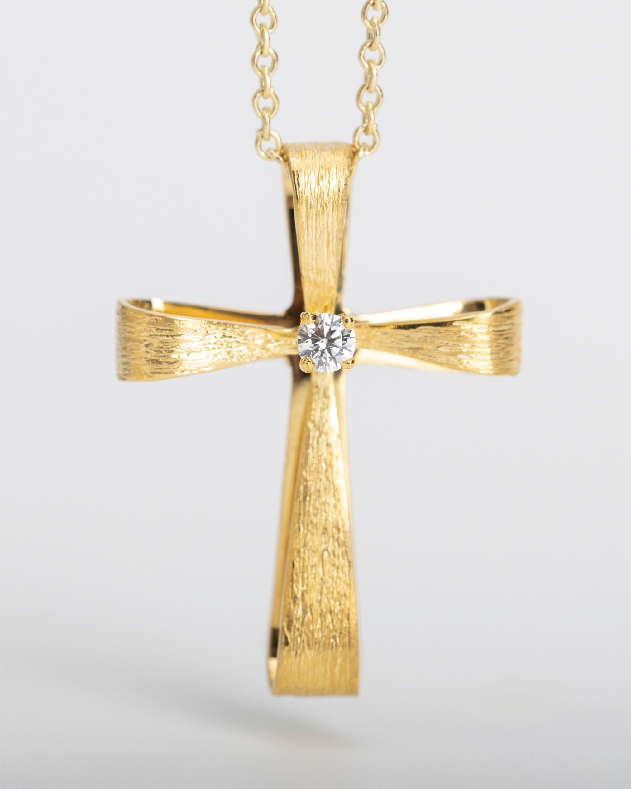 Cross in gold with a zircon stone